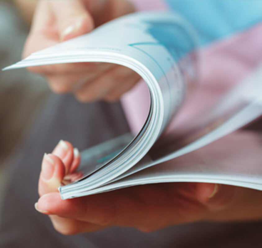 Stockfoto, Nahaufnahme einer Person, die ein Magazin liest